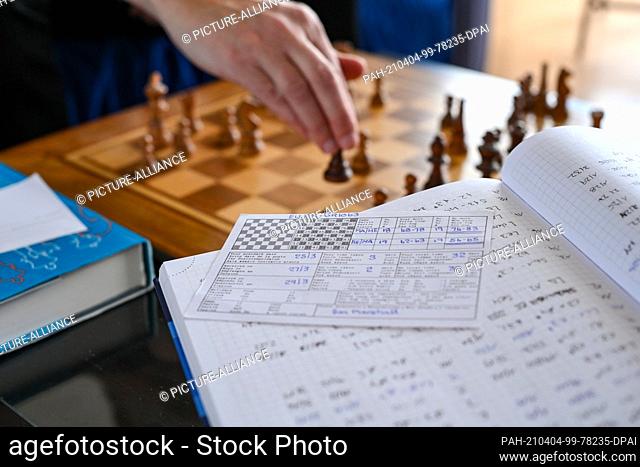 01 April 2021, Berlin: The chess player Heiermann plays correspondence chess by mail in his apartment and is surrounded by his notes and chess books