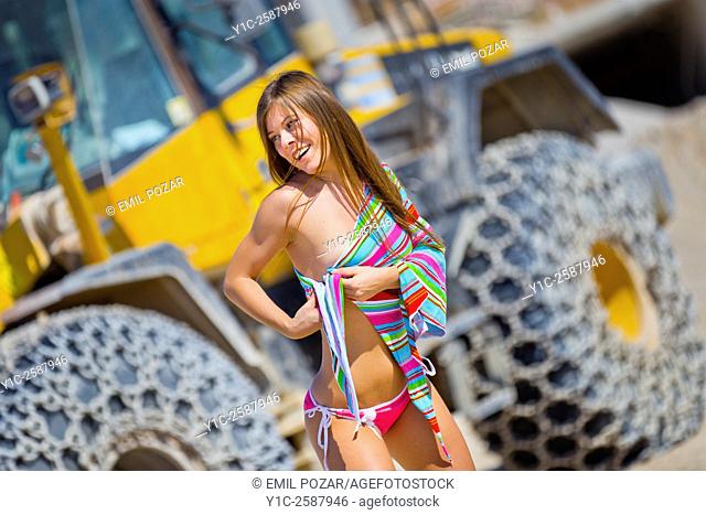 Young woman in bikini before big truck