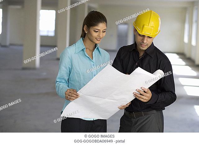 Businesspeople looking at blueprints