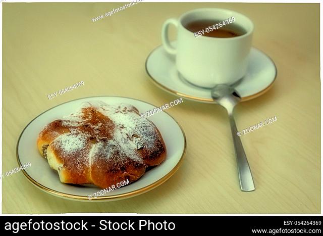 Breakfast: a Cup of coffee and bun on the plate
