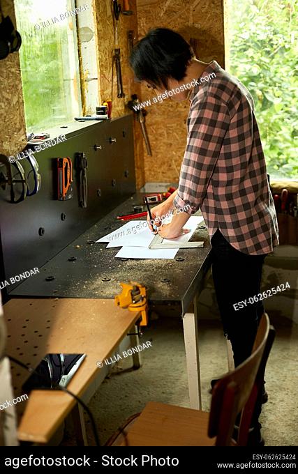 Female interior designer working on drawings, woman architect draws with ruler plan of new apartment design at workshop, design project blueprints for new...