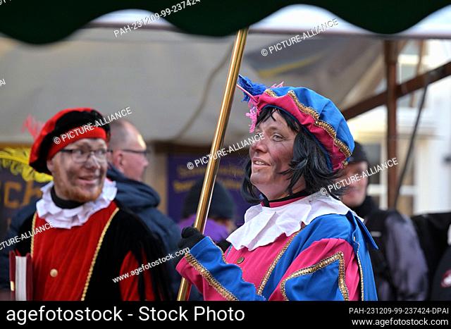 09 December 2023, Brandenburg, Potsdam: In the Netherlands and Flanders, Zwarte Piet (right) is the helper of the Dutch St. Nicholas, Sinterklaas