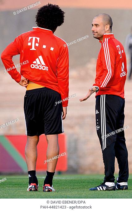 Bayern coach Pep Guardiola (R) talks to his player Dante during a practice session of Bayern Munich in Agadir, Morocco, 15 December 2013