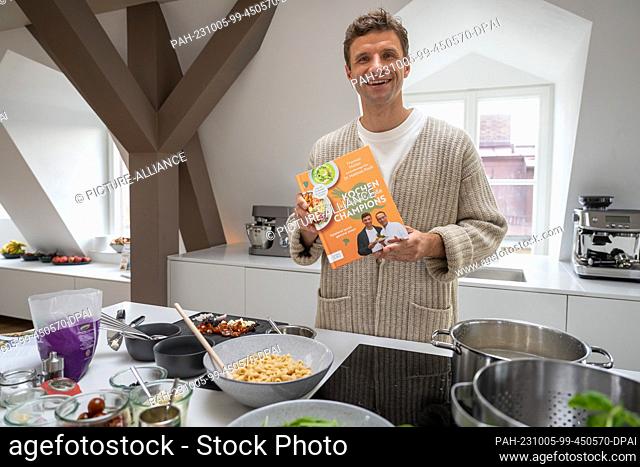 05 October 2023, Bavaria, Munich: National soccer player Thomas Müller puts the cookbook ""Kochen für kleine & große Champions - Spielend leicht gesund essen""...