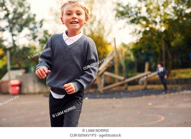 Portrait of elementary schoolboy running in playground