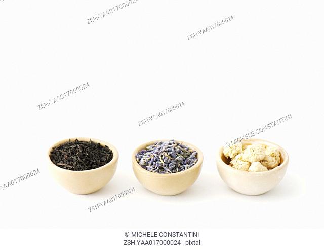 Three calabash bowls containing tea leaves, lavender, and chamomile flowers