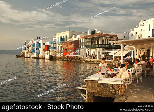 Tourists sitting at a cafe and watching the sunset at Little Venice district at the old town, Mykonos Island, Cyclades Islands, Greek Islands, Greece, Europe