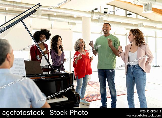 Businessman singing by colleagues snapping fingers