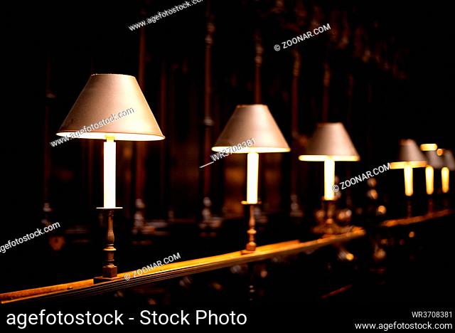 Row of decorative and stylish reading table lamps illuminating in a church