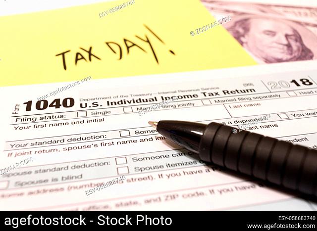 1040 income tax form with pen for 2018 showing tax day for filing on April 15