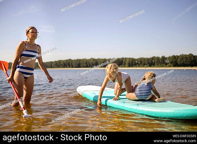 Mother with daughter having fun on paddle board
