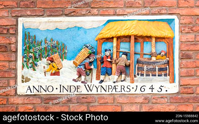 Haarlem, The Netherlands - May 31, 2019: Colorful wall sculpture with a scene symbolizing wine making anno 1645 in Haarlem in the Netherlands