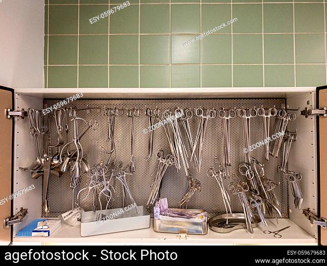 in a sterilization unit on a shelf, all these surgical instruments are hanging