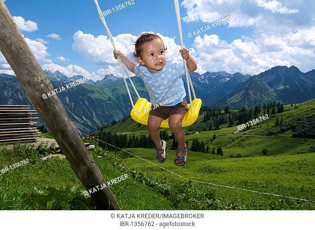 Child swinging on a swing, Schlappoltalm, alpine meadow on Fellhorn Mountain, Oberstdorf, Allgaeu, Bavaria, Germany, Europe