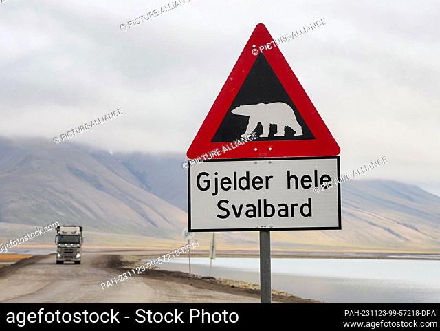 22 August 2023, Norway, Longyearbyen: A sign on the road to Longyearbyen warns of polar bears and reads ""Gjelder hele Svalbard"" (Applies to the whole of...