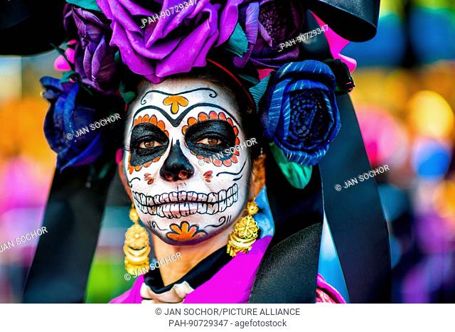 A young woman, dressed as La Catrina, a Mexican pop culture icon representing the Death, performs during the Day of the Dead festival in Mexico City, Mexico