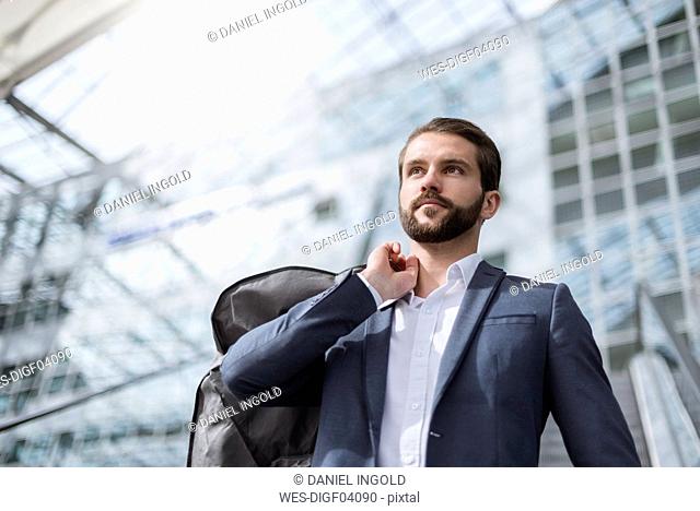 Portrait of young businessman on escalator