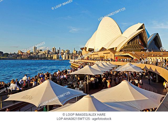 People meeting in the bars along the quay side at Sydney harbour underneath the Sydney opera house
