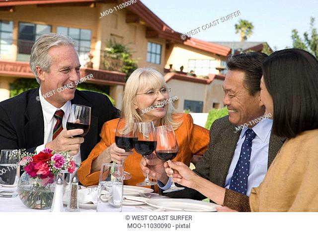 Two couples toasting outdoors