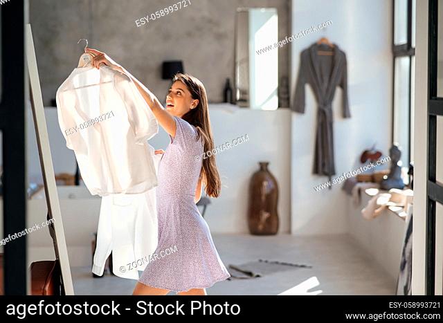 Beautiful girl trying dress at home
