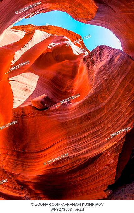 Fantastic slot canyon Antelope in the Navajo reservation. Mysterious purple - red tunnel and blue sky. Arizona, USA