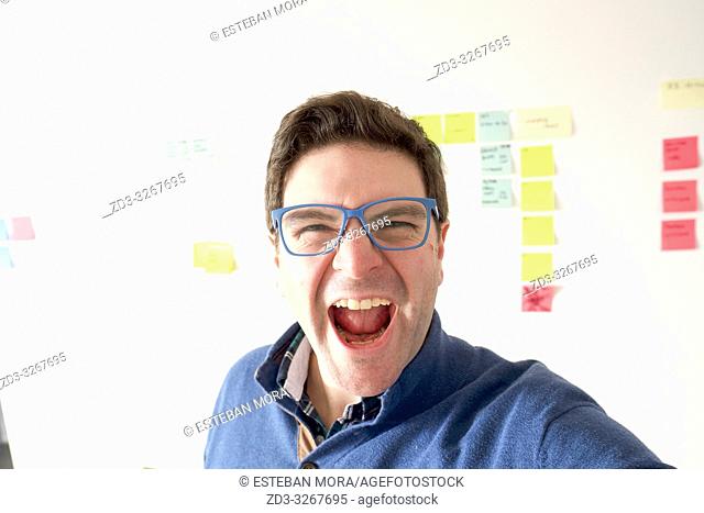 man screaming in front of a wall full of sticky notes