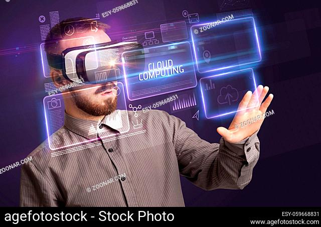 Businessman looking through Virtual Reality glasses with CLOUD COMPUTING inscription, new technology concept