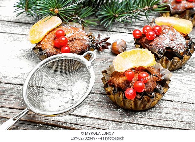 Christmas cupcakes iron plates on wooden background with Christmas tree