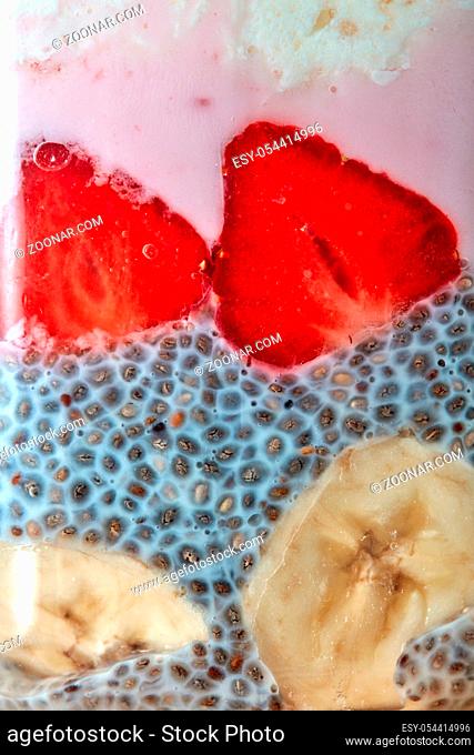 Close-up halves of ripe strawberry slices of banana and chia seeds with yogurt. Dietary health food