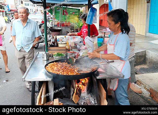 cooking stir fried cha kueh in a wok in Penang, Malaysia