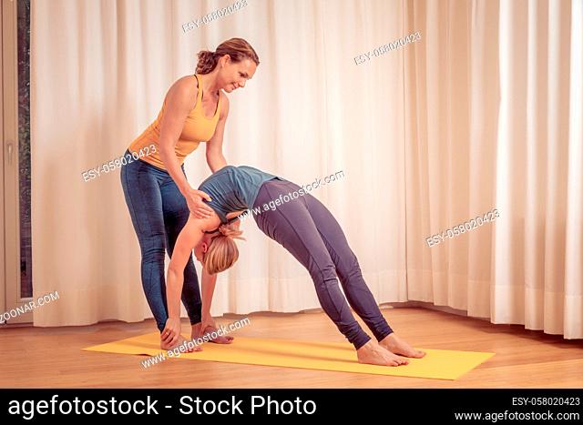 An image of two women doing yoga at home