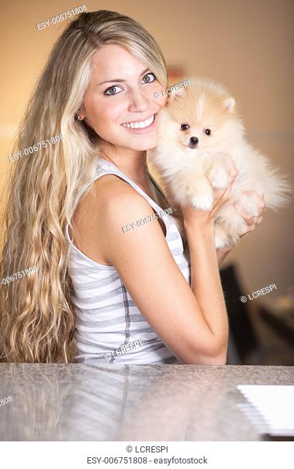 young woman playing with her tinny dog at home