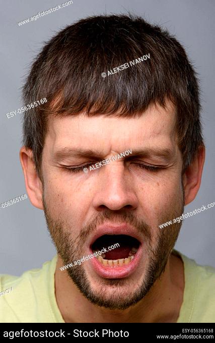 Close-up portrait of a yawning man of European appearance