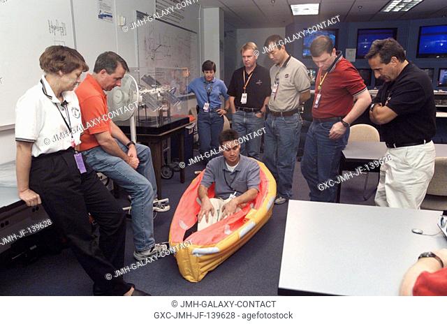 The STS-114 crewmembers are briefed by United Space Alliance (USA) crew trainer Adam G. Flagan (seated) during a classroom session preceding water survival...