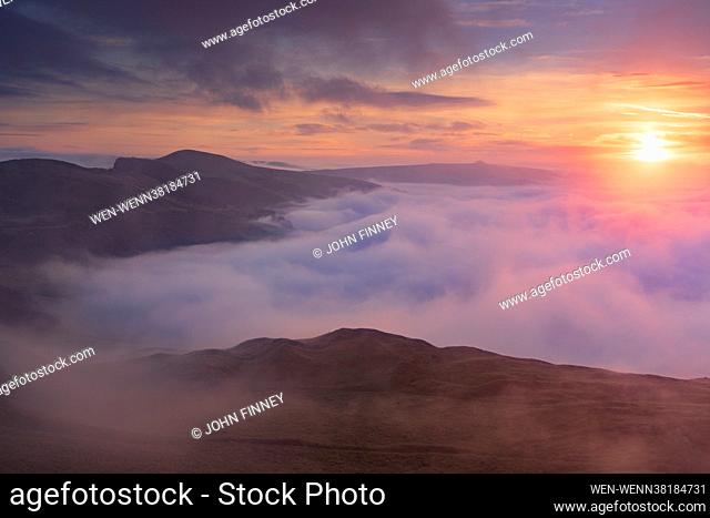 The view from Little mam Tor looking down Hope Valley with the light from the rising sun catching the swirling fog over the Derbyshire Peak District