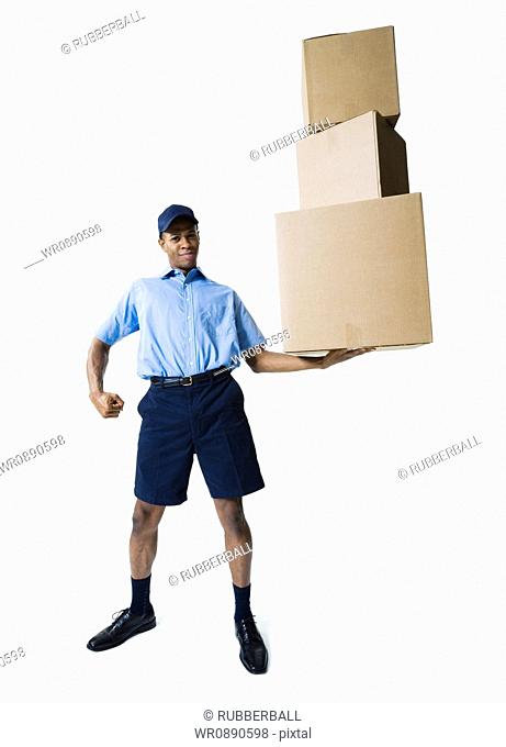 Portrait of a delivery man holding a stack of boxes