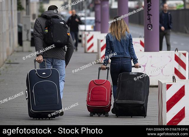 05 June 2020, Hessen, Frankfurt/Main: Residents with wheeled suitcases leave the restricted area of the planned bomb disposal