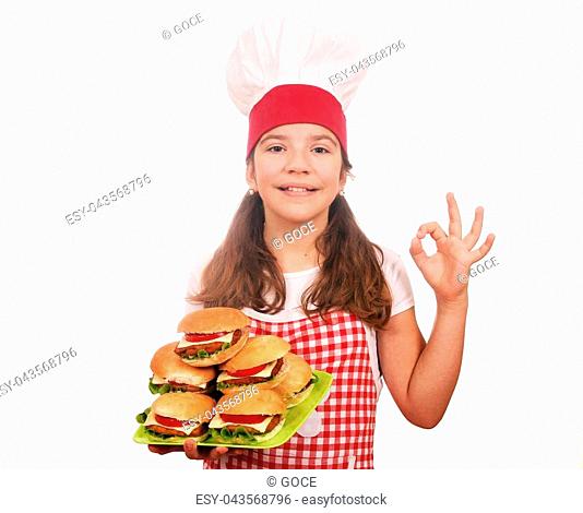 happy little girl cook with hamburgers and ok hand sign