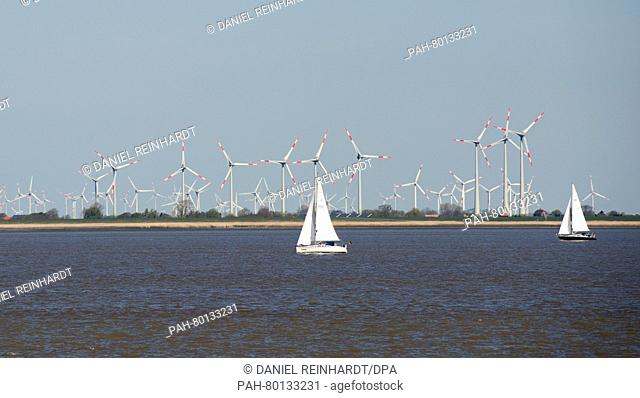 Sailboats sailing on off the coast of Schleswig-Holstein in the North Sea in Germany, 05 May 2016. In the background a number of wind turbines are to be seen