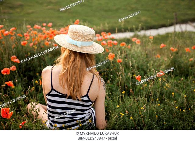 Caucasian woman sitting in wildflowers