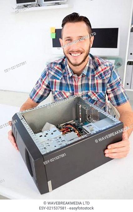 Computer engineer smiling at camera beside open console