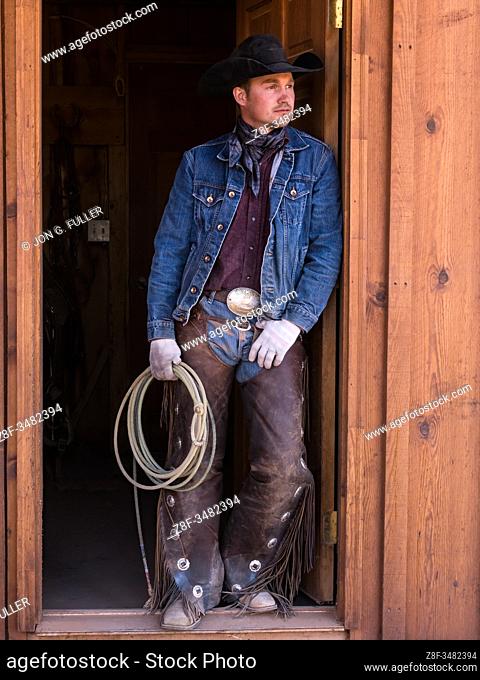 A cowboy wrangler with his lariat on the Red Cliffs Ranch near Moab, Utah. He wears leather chaps to protect his legs from thorny brush while riding the range