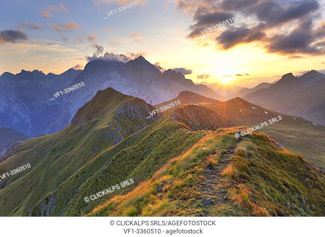 Sunset on the Marmolada Group seen from the grassy summit of Migogn Mount, Dolomites, Marmolada group, Rocca Pietore, Belluno province, Veneto, Italy