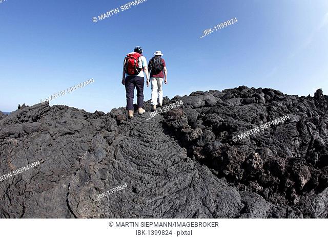 Hikers on the coast in Timanfaya National Park, Lanzarote, Canary Islands, Spain, Europe