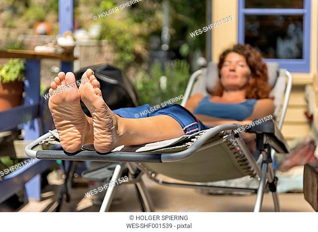 New Zealand, South Island, Nelson, woman resting barefooted in a deck chair