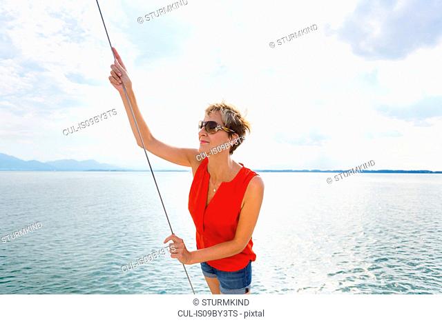 Mature woman sailing on Chiemsee lake, Bavaria, Germany