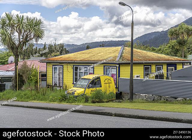 FRAANZ JOSEF, NEW ZEALAND - November 18 2019: cityscape with yellow house and van overwhelmed by vegetation at touristic village