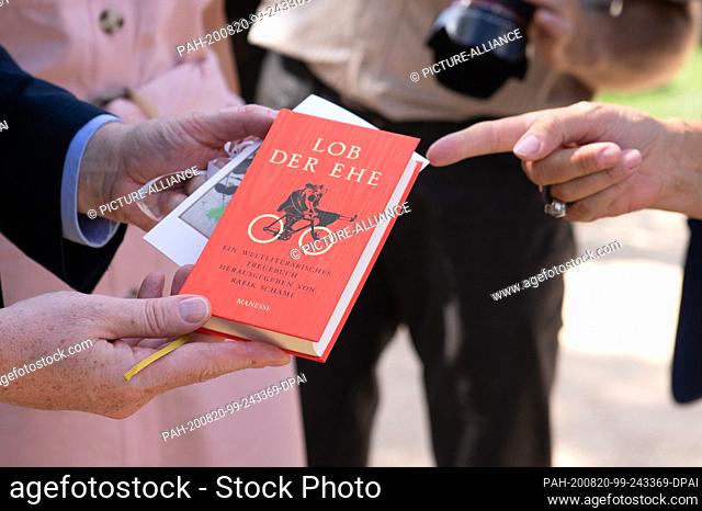 20 August 2020, Saxony, Bad Muskau: Michael Kretschmer (CDU, l), Prime Minister of Saxony, receives the book ""Praise of Marriage"" by Rafik Schami from Monika...
