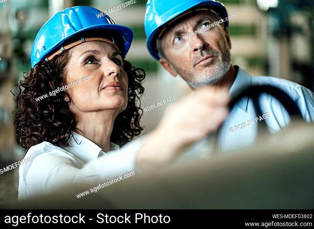 Engineer team with hardhat checking machine at industry