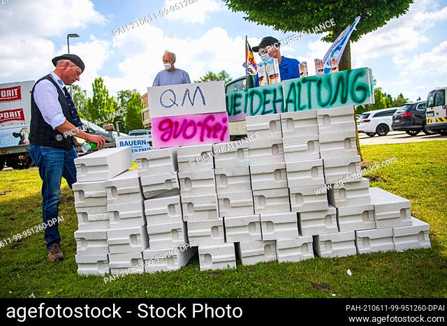 11 June 2021, Lower Saxony, Edewecht: Dairy farmers demonstrate for reasonable milk prices by building a wall in front of the DKM Deutsches Milchkontor building